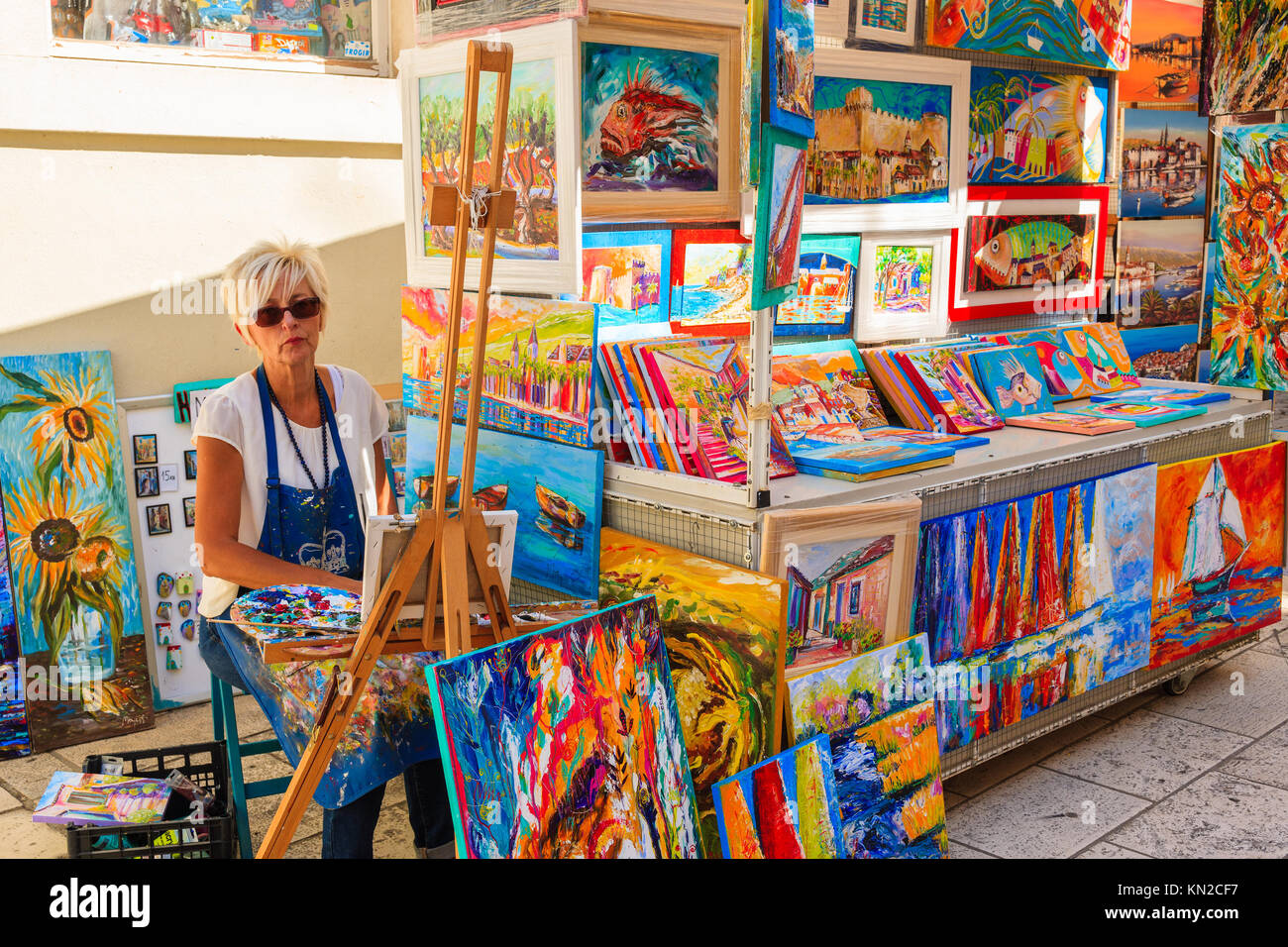 TROGIR TOWN, CROATIA - SEP 6, 2017: woman artist painting and selling pictures in old town of Trogir, Dalmatia, Croatia. Stock Photo