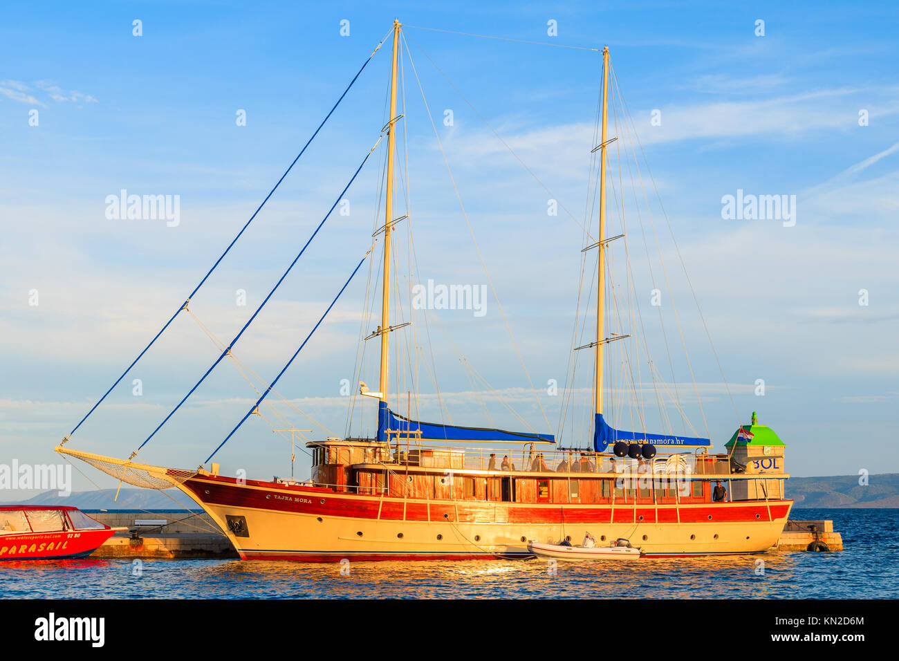 BOL TOWN, CROATIA - SEP 7, 2017: Traditional wooden yacht boat anchoring in Bol port at sunset time, Brac island, Croatia. Stock Photo