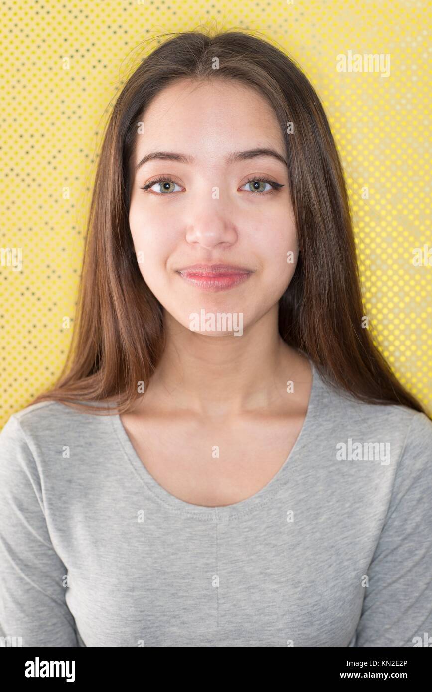 Beautiful teenage girl standing in front of funky yellow wall Stock Photo