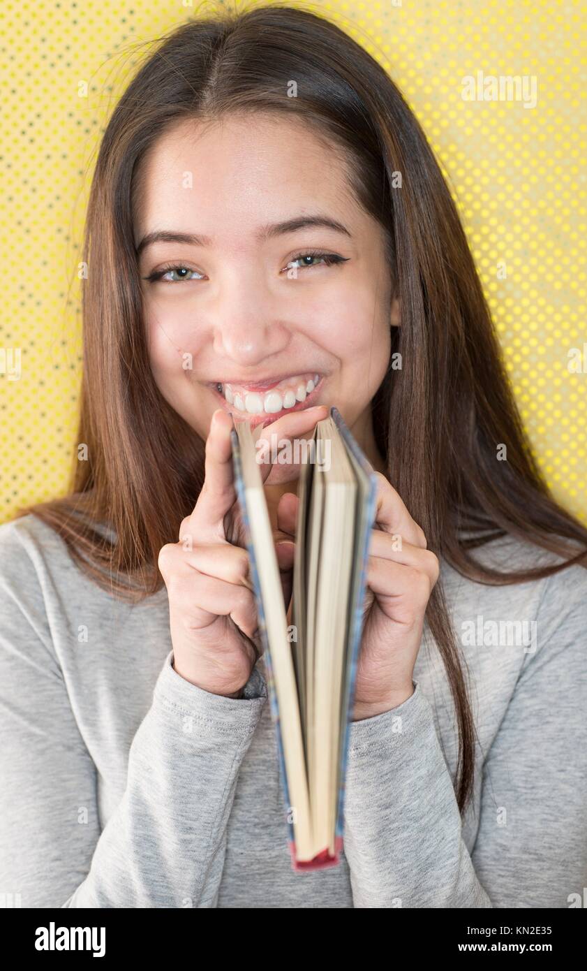 Beautiful teenage girl hold a book and laugh Stock Photo