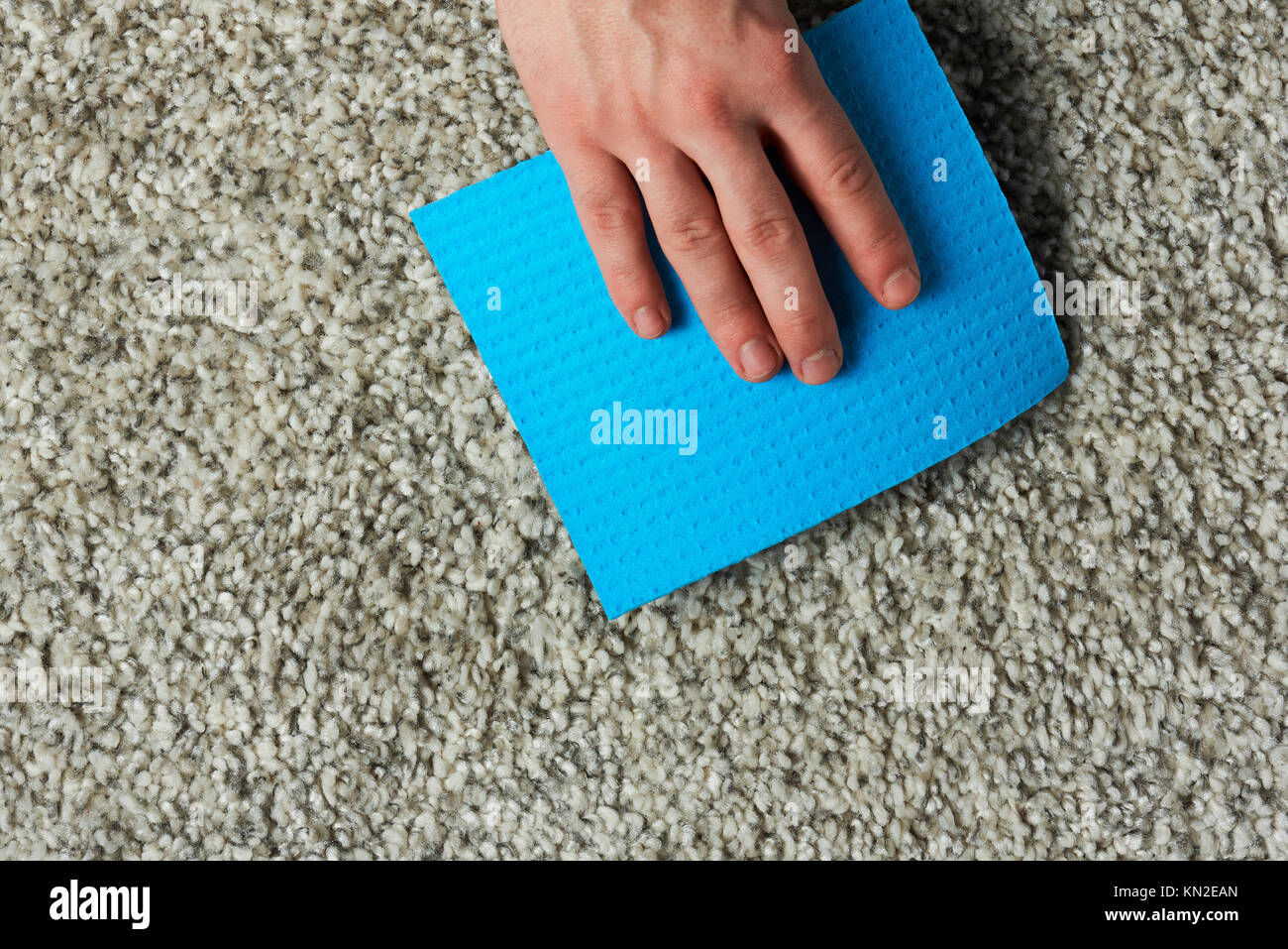 Covering dirty spot on carpet with blue napkin Stock Photo