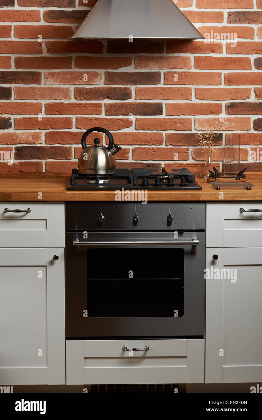 Design of modern kitchen front view. Grungy kitchen design with brick wall Stock Photo