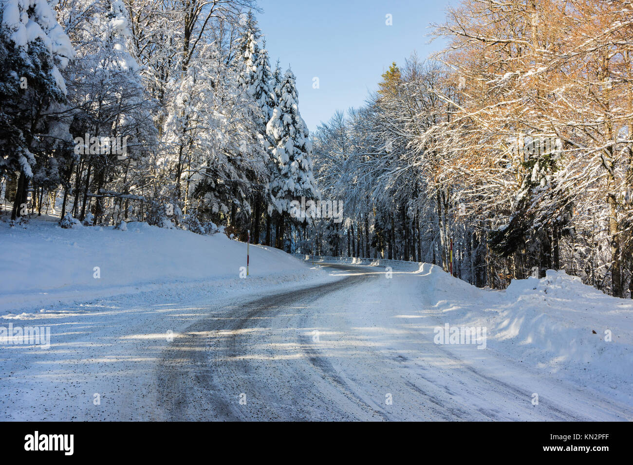 A snowy and icy road curve in the Vosges mountains (France) in winter - december 2017 - horizontal Stock Photo