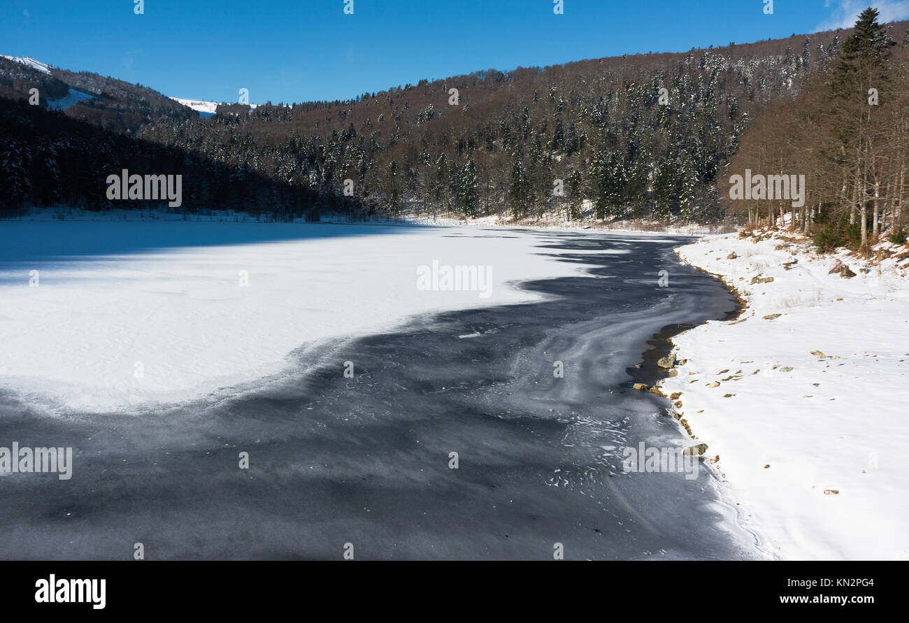 Frozen Lauch Lake in winter on a sunny day, Vosges, France. Stock Photo