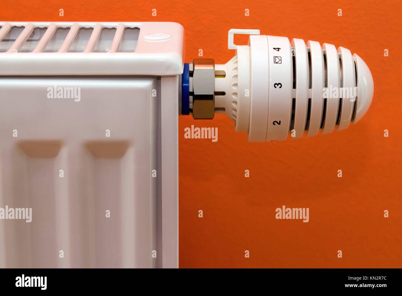Radiator heater with thermostat isolated on orange background Stock