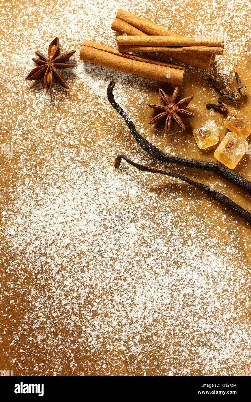Anise stars, cinnamon sticks, vanilla beans and brown sugar on sugar  background Stock Photo - Alamy