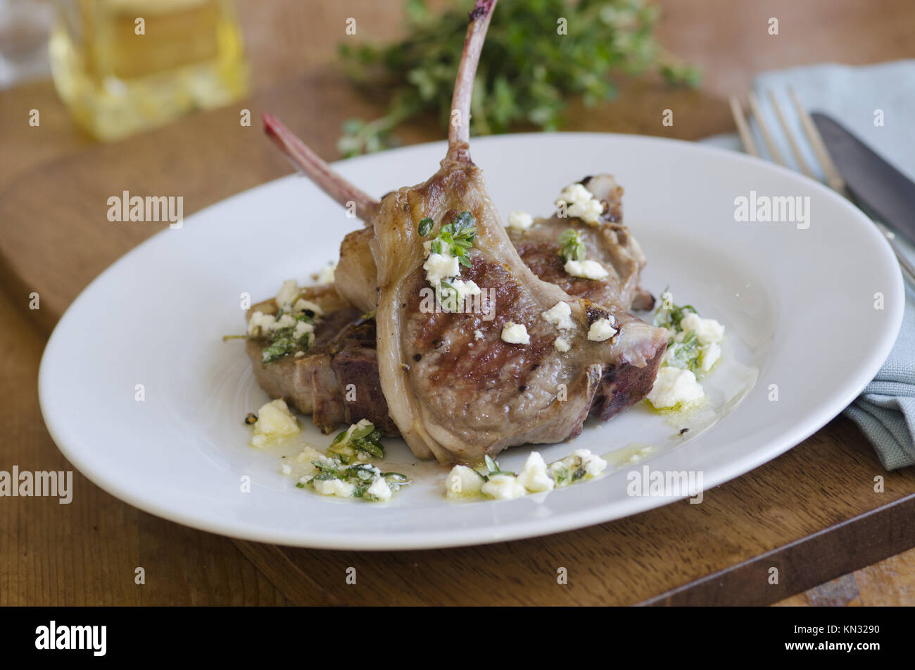 Grilled lamb chops with crumbled feta and herbs on a plate Stock Photo