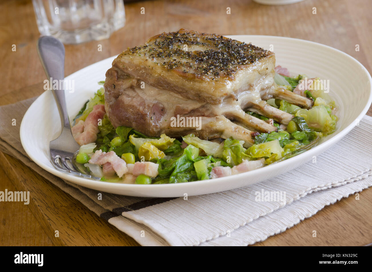 Roast rack of lamb with peas, lettuce and bacon Stock Photo Alamy