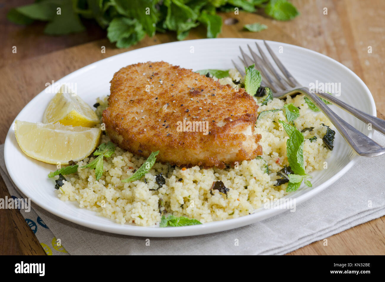 Chicken breaded steak with lemon and courgette couscous Stock Photo Alamy