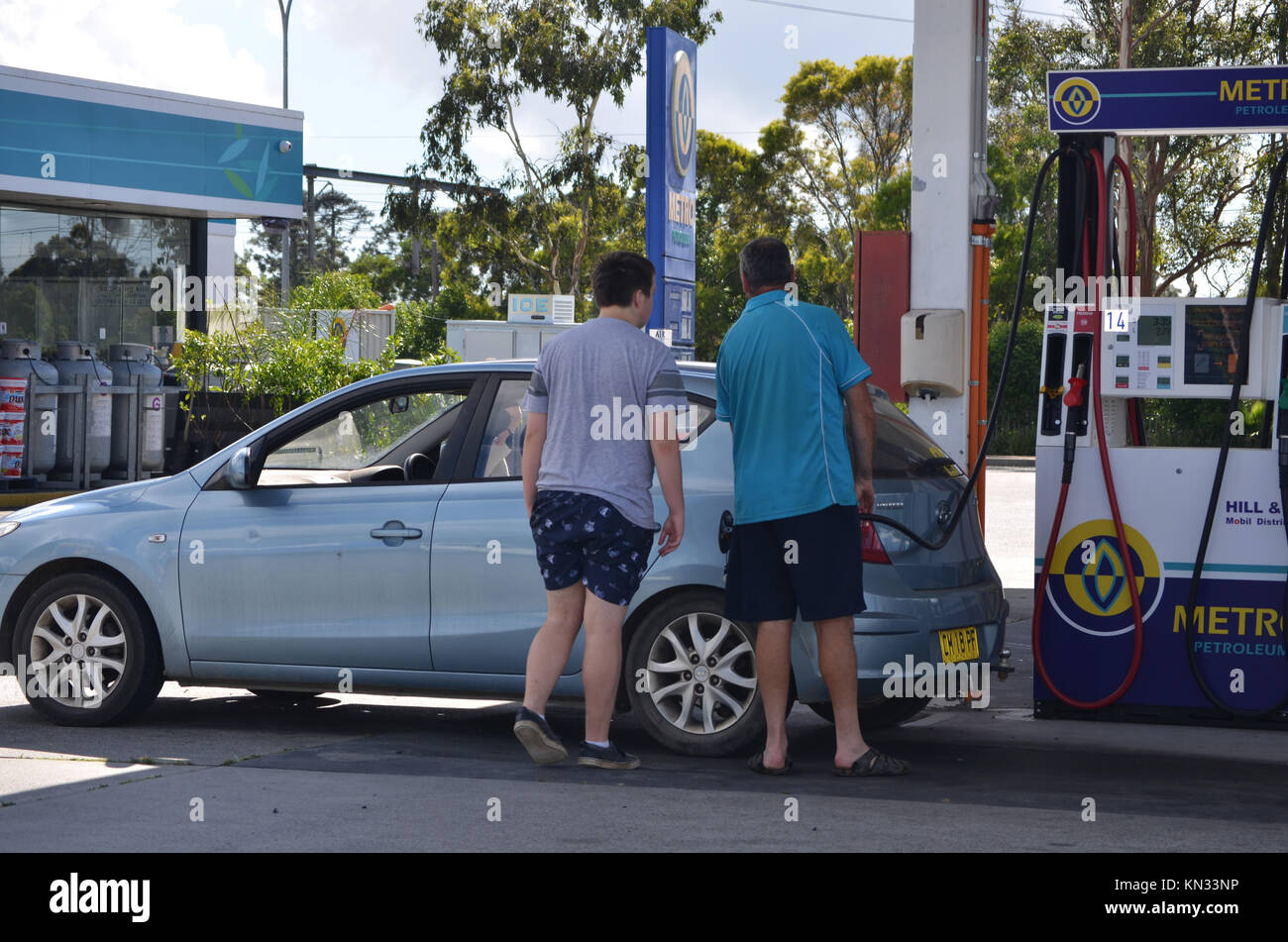 Father and son filling car with petrol at service station Stock Photo