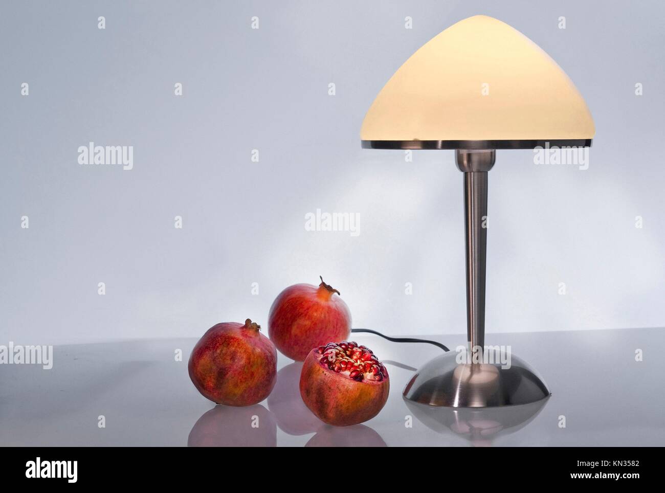 Still life with lamp and pomegranates. Stock Photo
