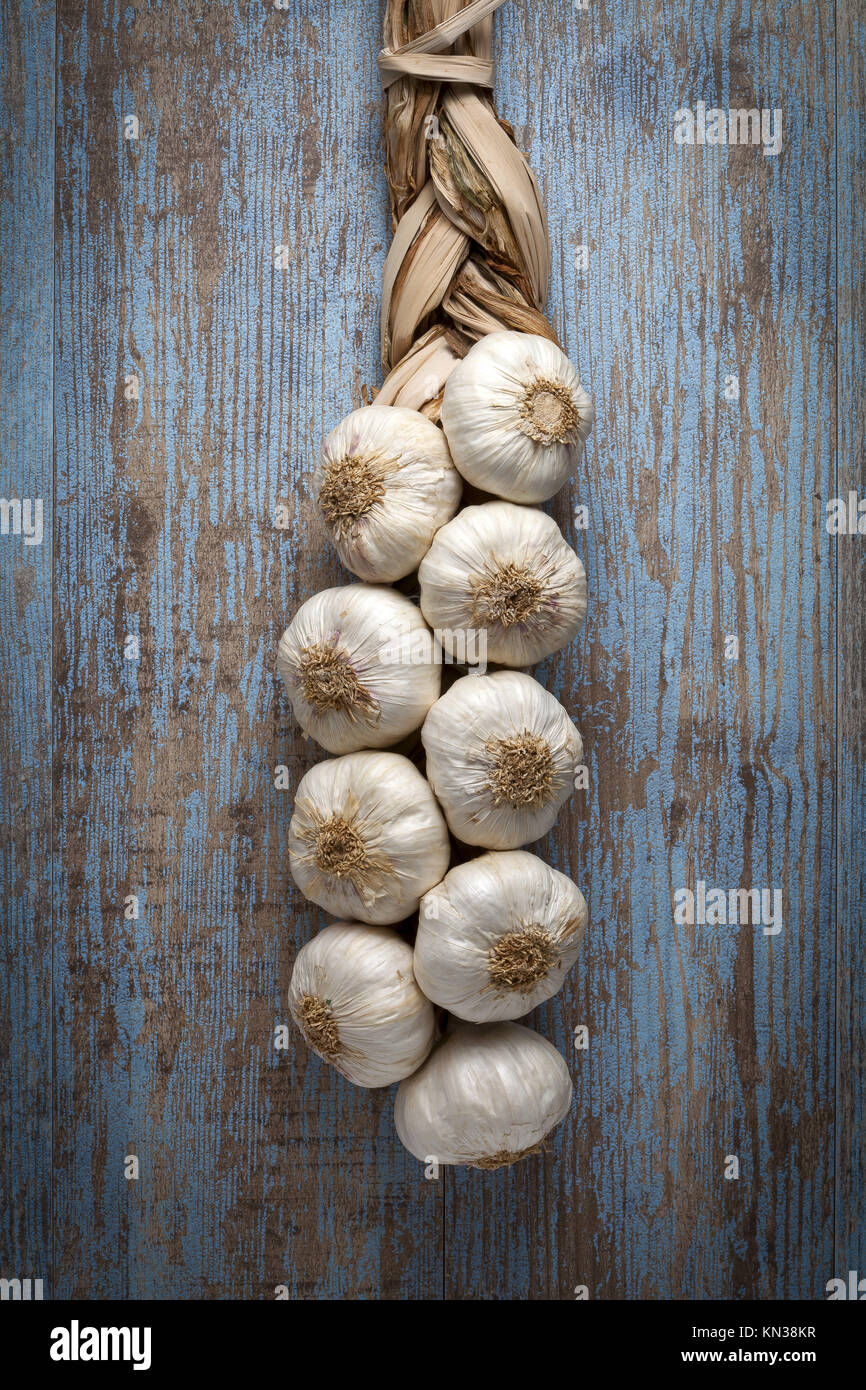 String of garlic on wooden background. Stock Photo