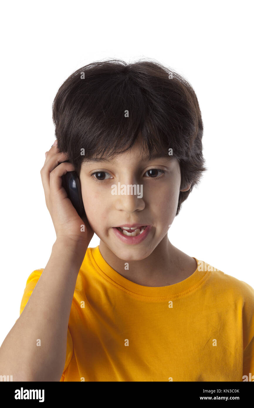 Eight year old boy with mobile phone on white background. Stock Photo