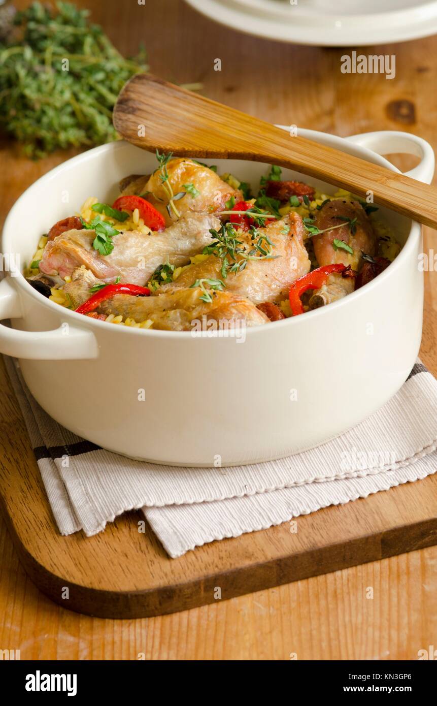 Grilled chicken with chorizo, rice and herbs in a cooking pot. Stock Photo