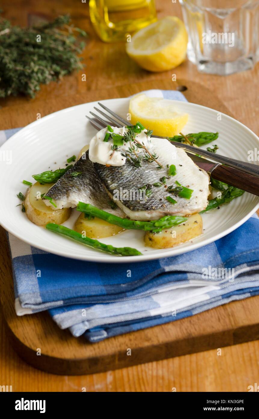 Grilled seabass with asparagus and new potatoes on a plate. Stock Photo