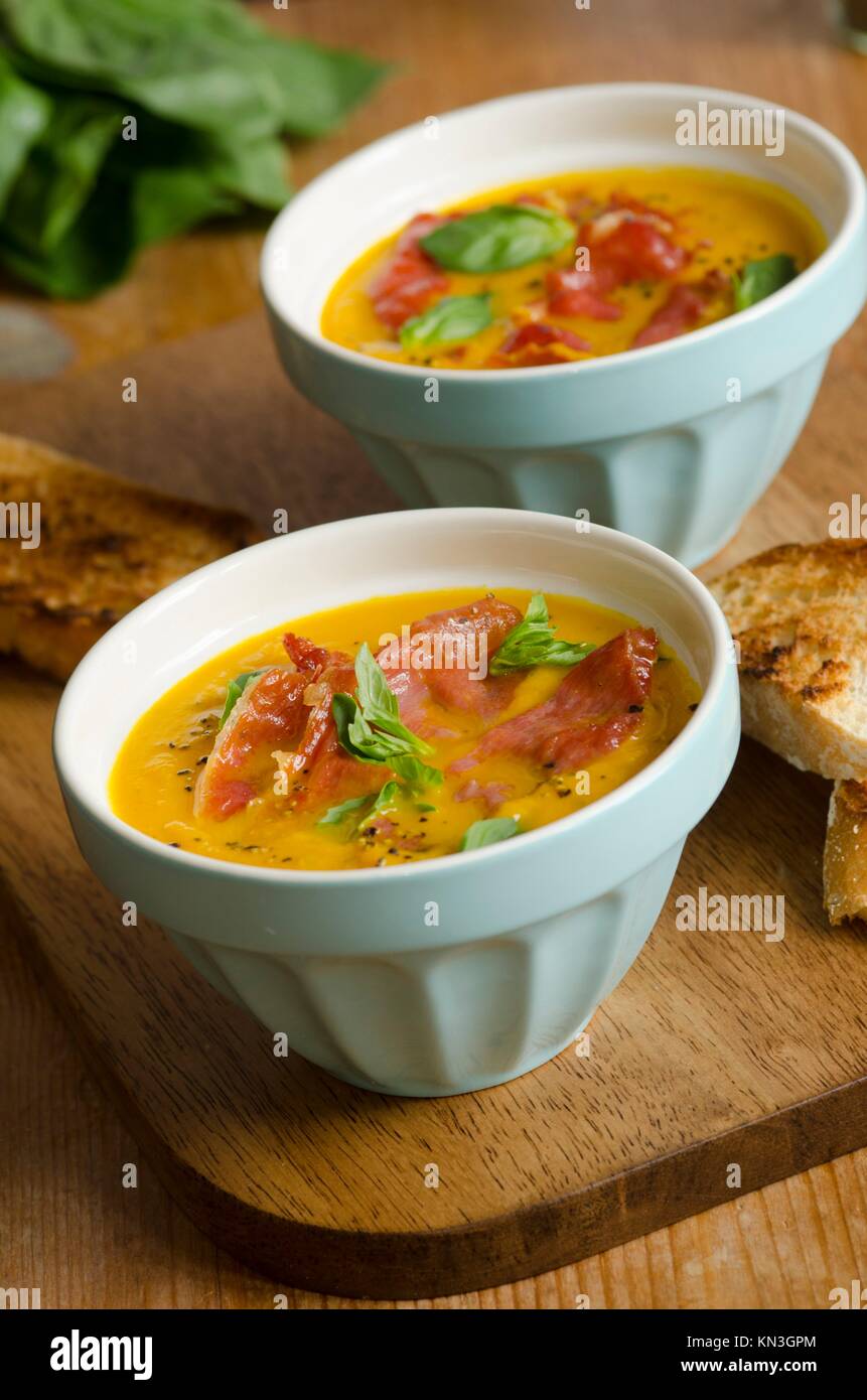 Chilled melon soup with crisp Serrano ham and basil. Stock Photo