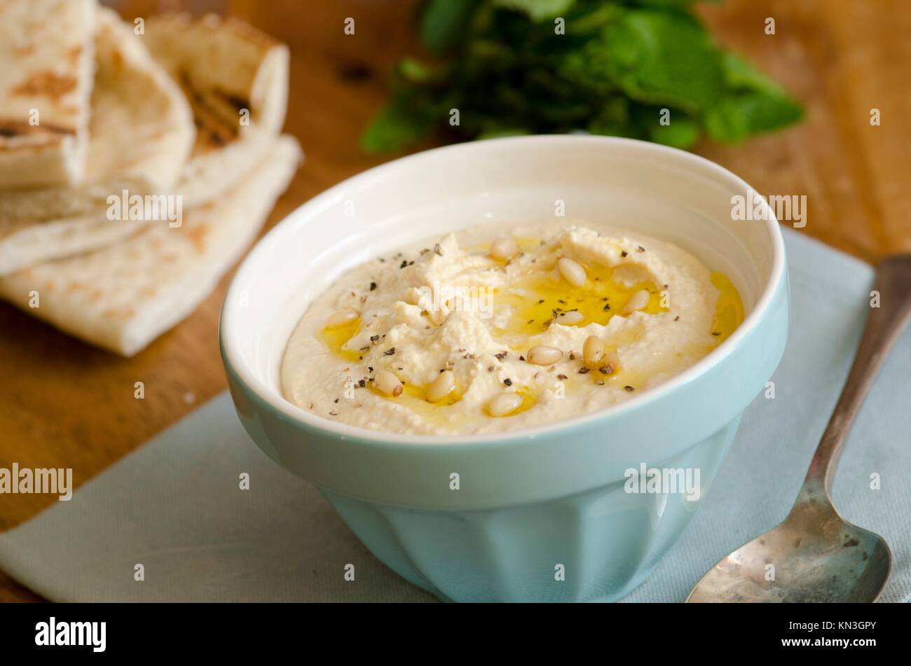 Healthy hummus with pine nuts and pita bread. Stock Photo