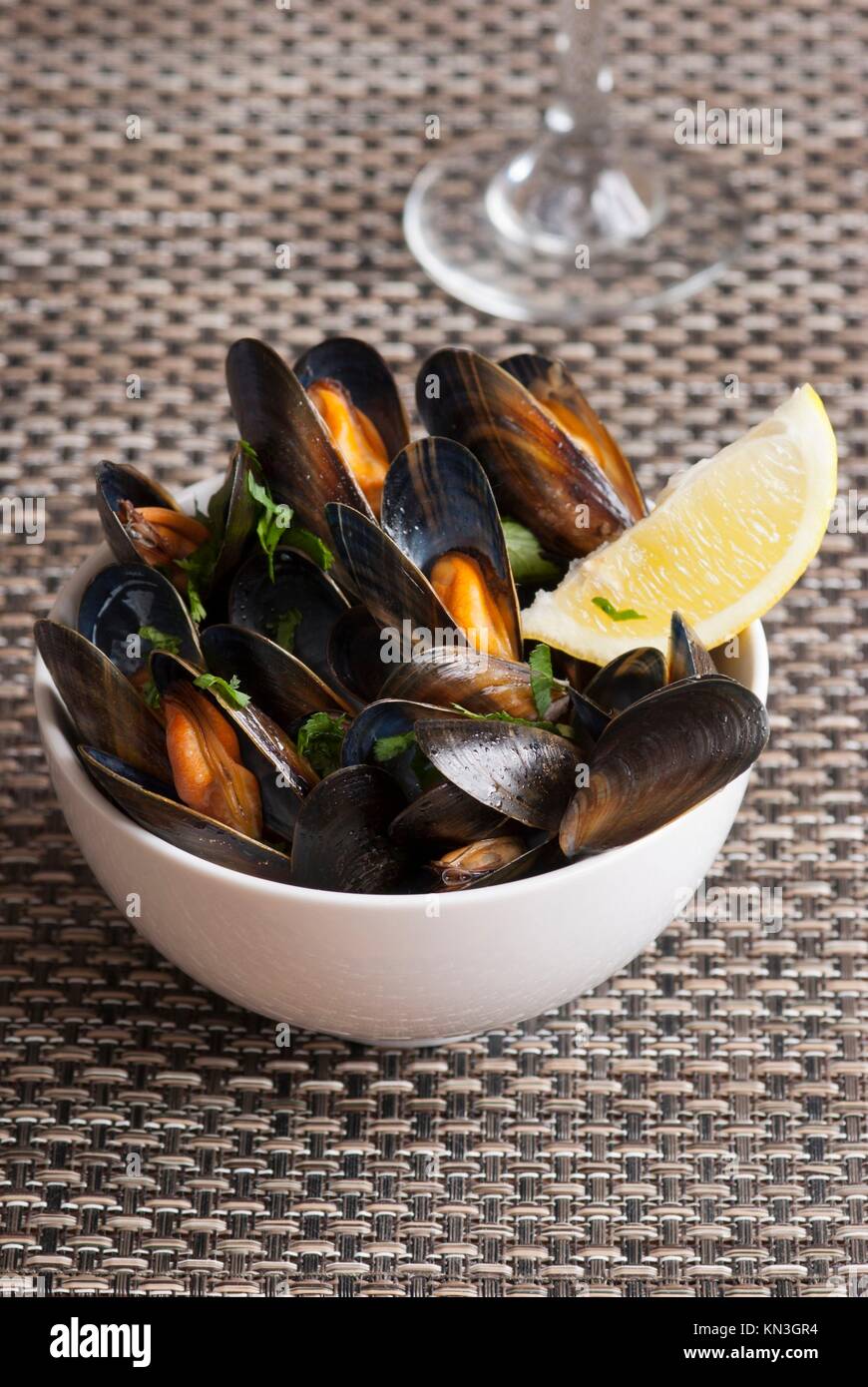 Fresh mussels with herbs in white wine sauce. Stock Photo