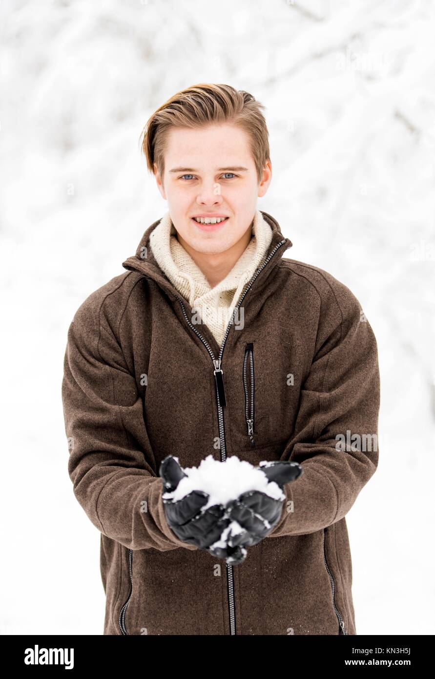 Christmas scene with natural looking teenage male outdoors in snow covered winter landscape. Stock Photo