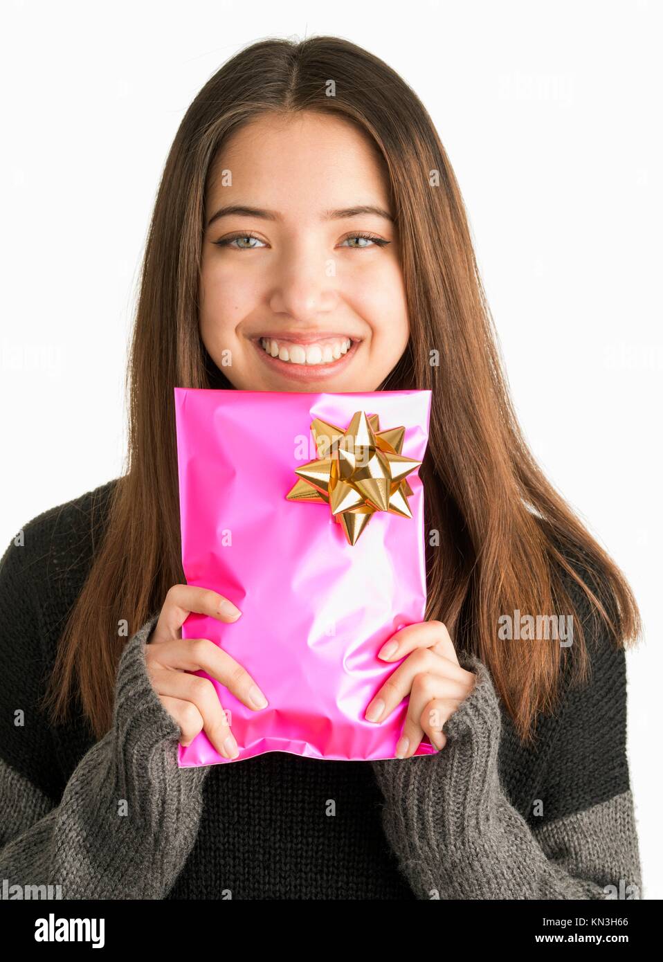 Happy beautiful teenage girl with christmas gift in pink wrapping. Stock Photo