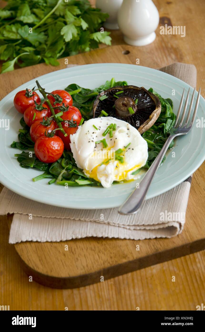 Poached egg with spinach, Portobello mushroom and vine tomatoes Stock
