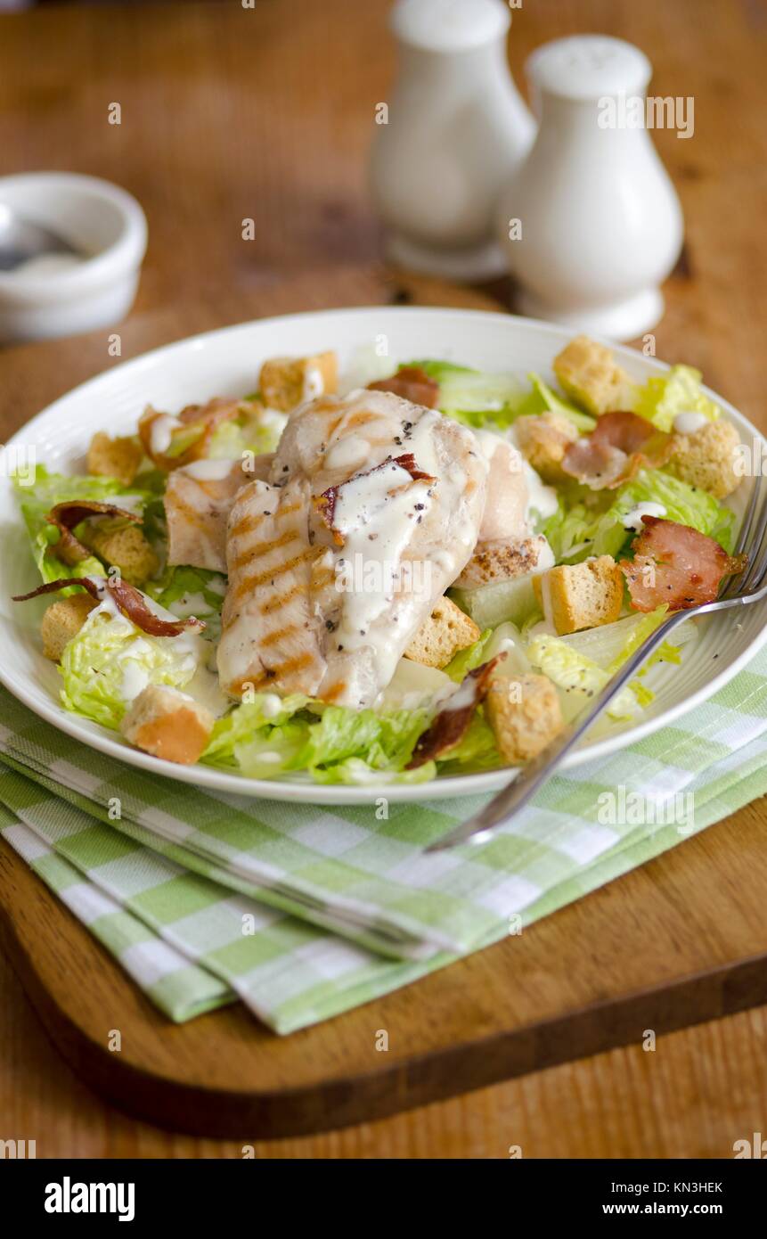 Griddled chicken breast with caesar salad on a plate. Stock Photo
