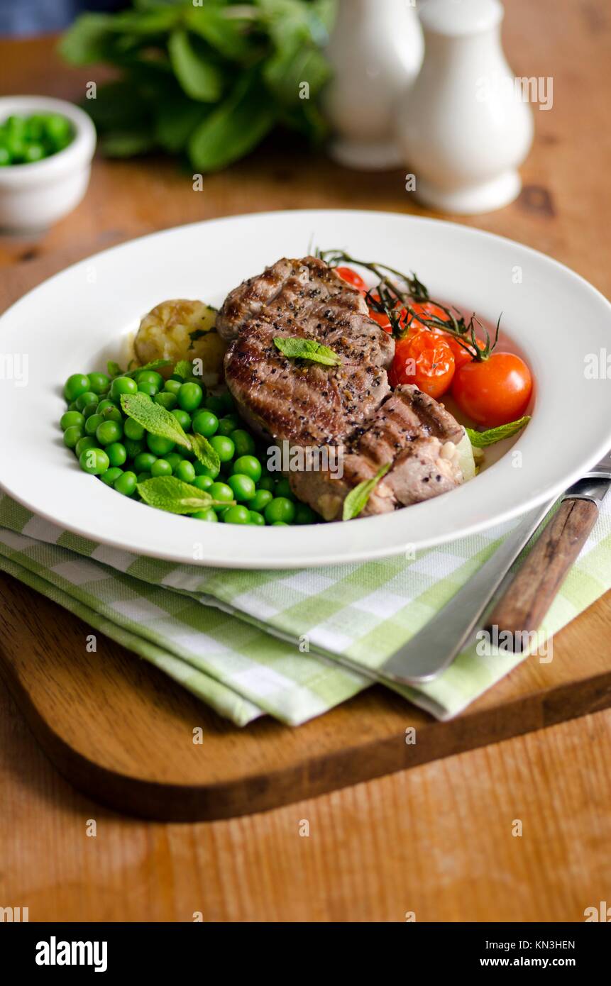 Griddled lamb steaks with honey and minted peas. Stock Photo