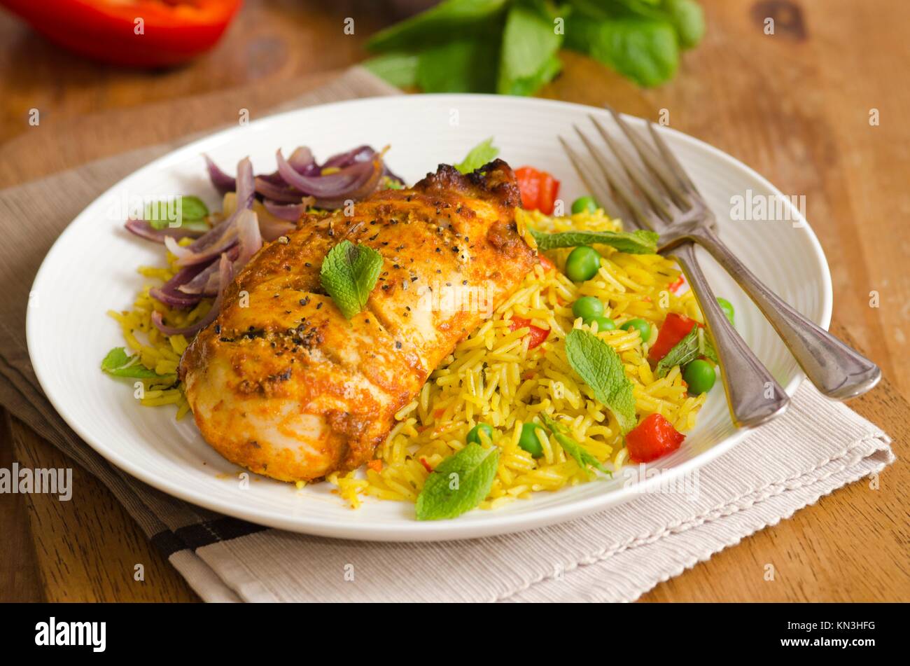 Chicken tikka with spiced rice, red onions and mint. Stock Photo