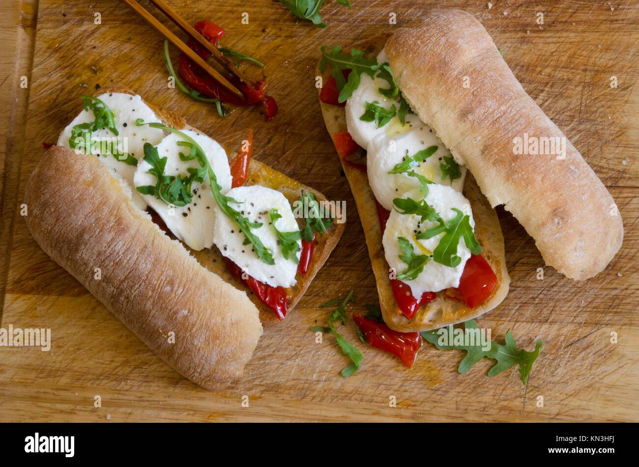 Toasted ciabattas filled with mozzarella, rocket and roasted peppers. Stock Photo
