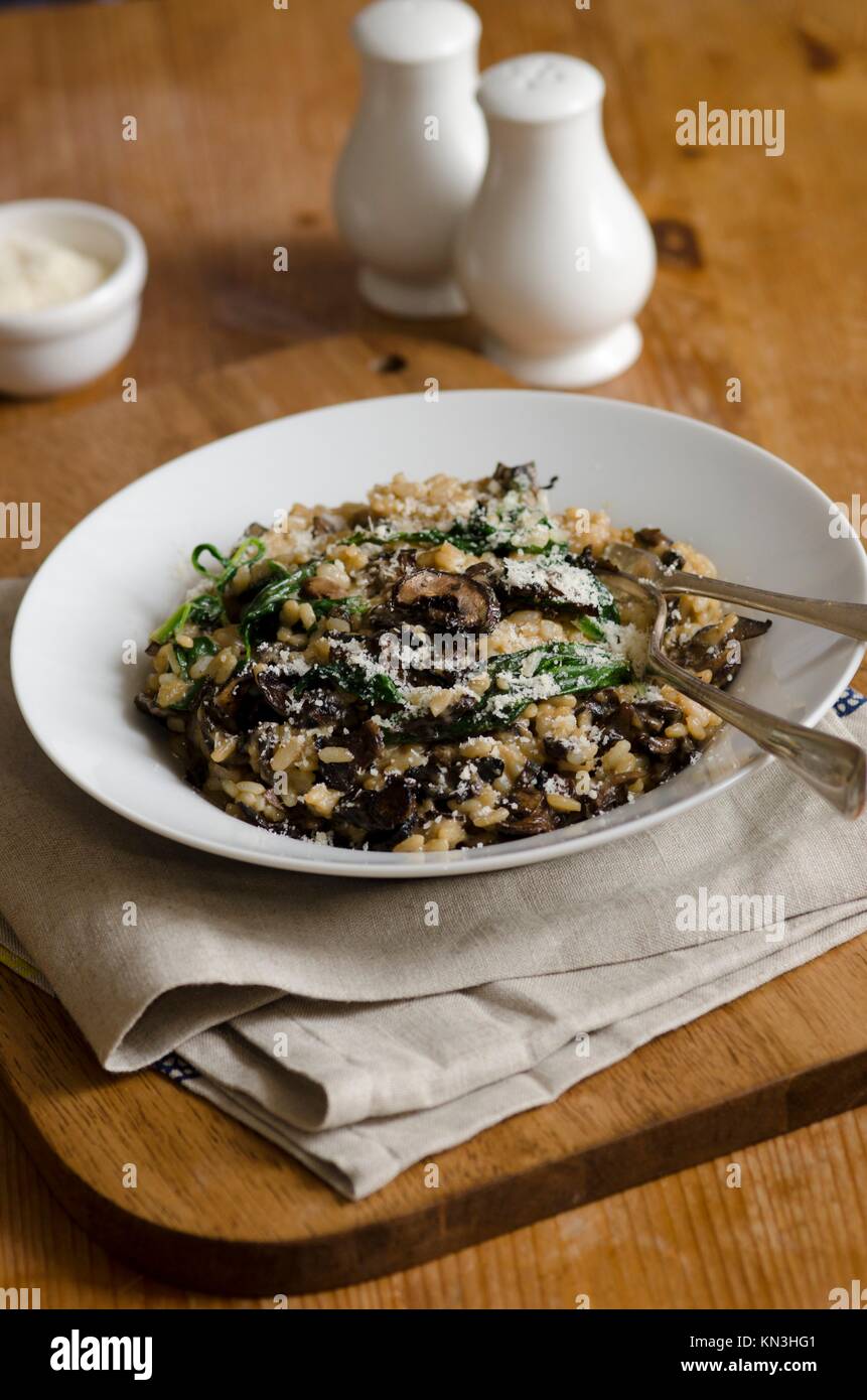 Mushroom risotto with spinach topped with grated Parmesan. Stock Photo