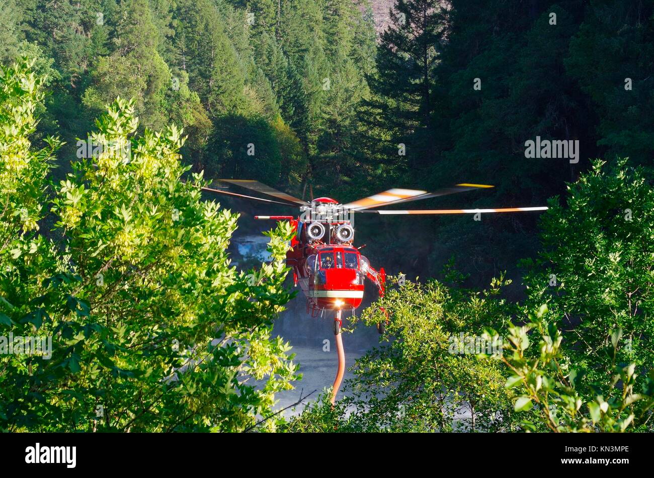 A U.S. Forest Service helicopter fills its water tank from a river to