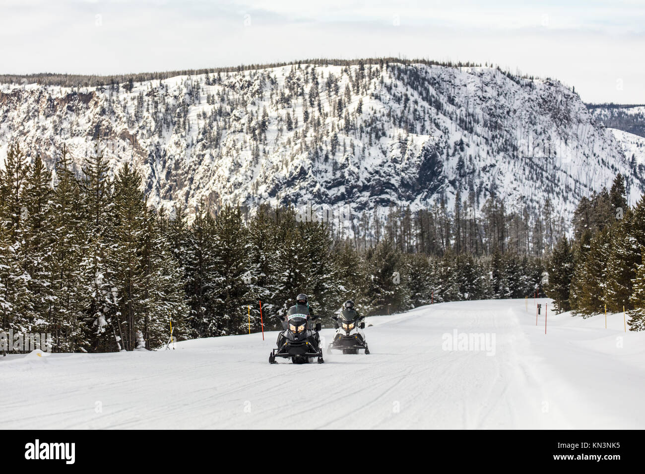 Tourists ride snowmobiles past the National Park Mountain in the winter