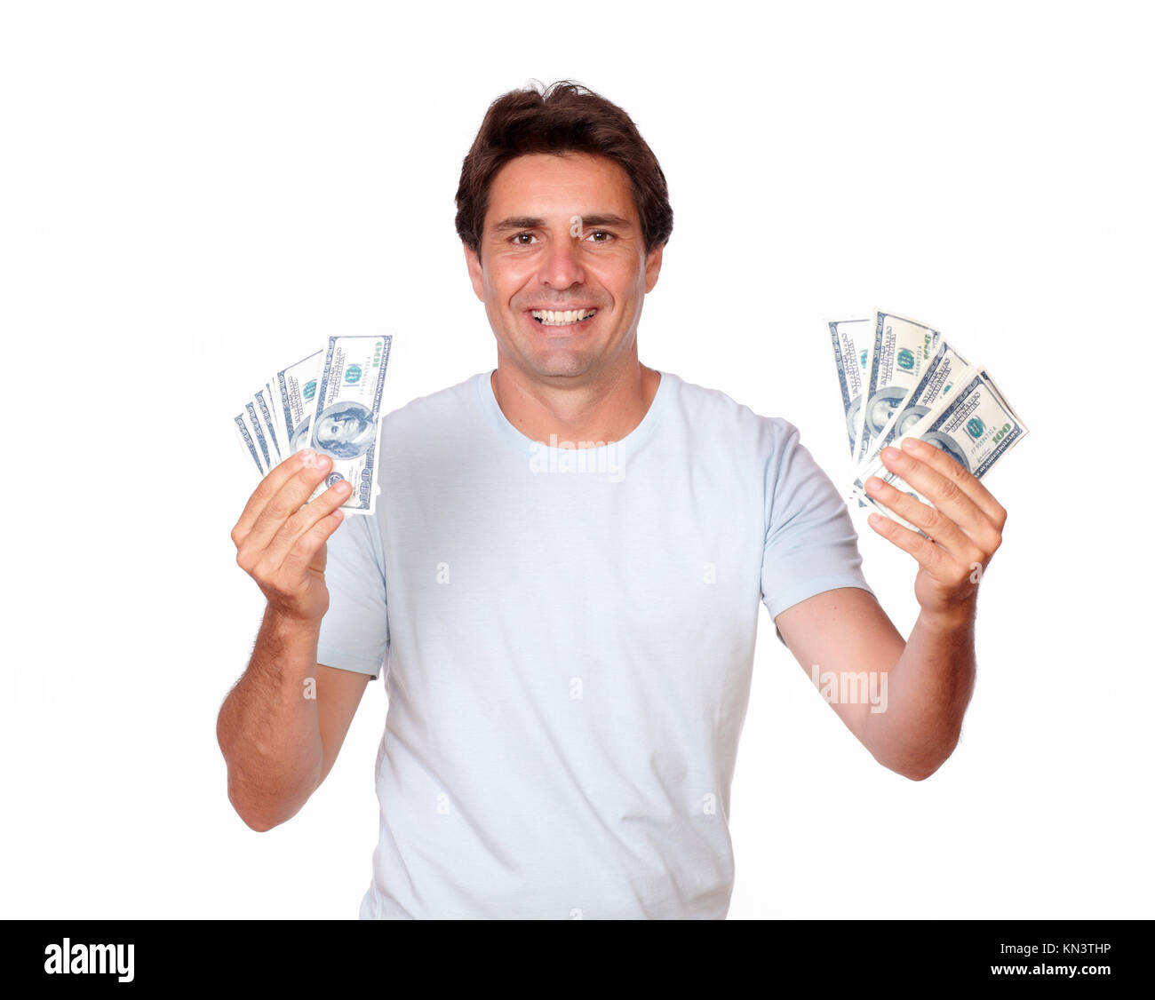 Portrait of a charismatic hispanic adult holding cash money on white background. Stock Photo