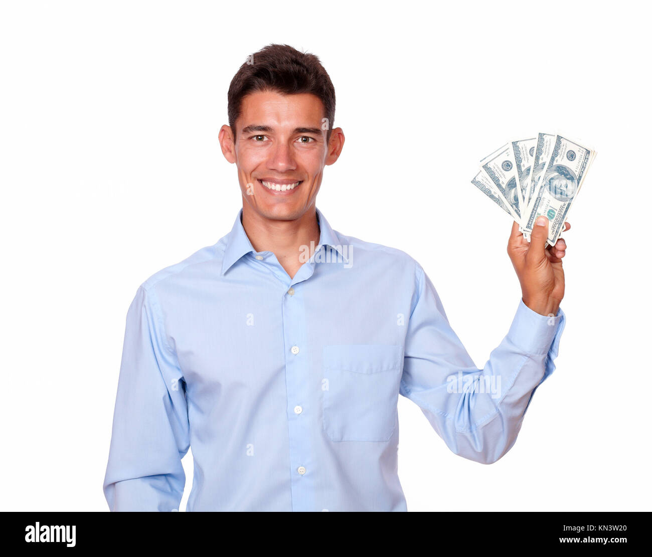 A portrait of an ambitious man on blue shirt smiling and holding cash dollars while looking at you on isolated background. Stock Photo