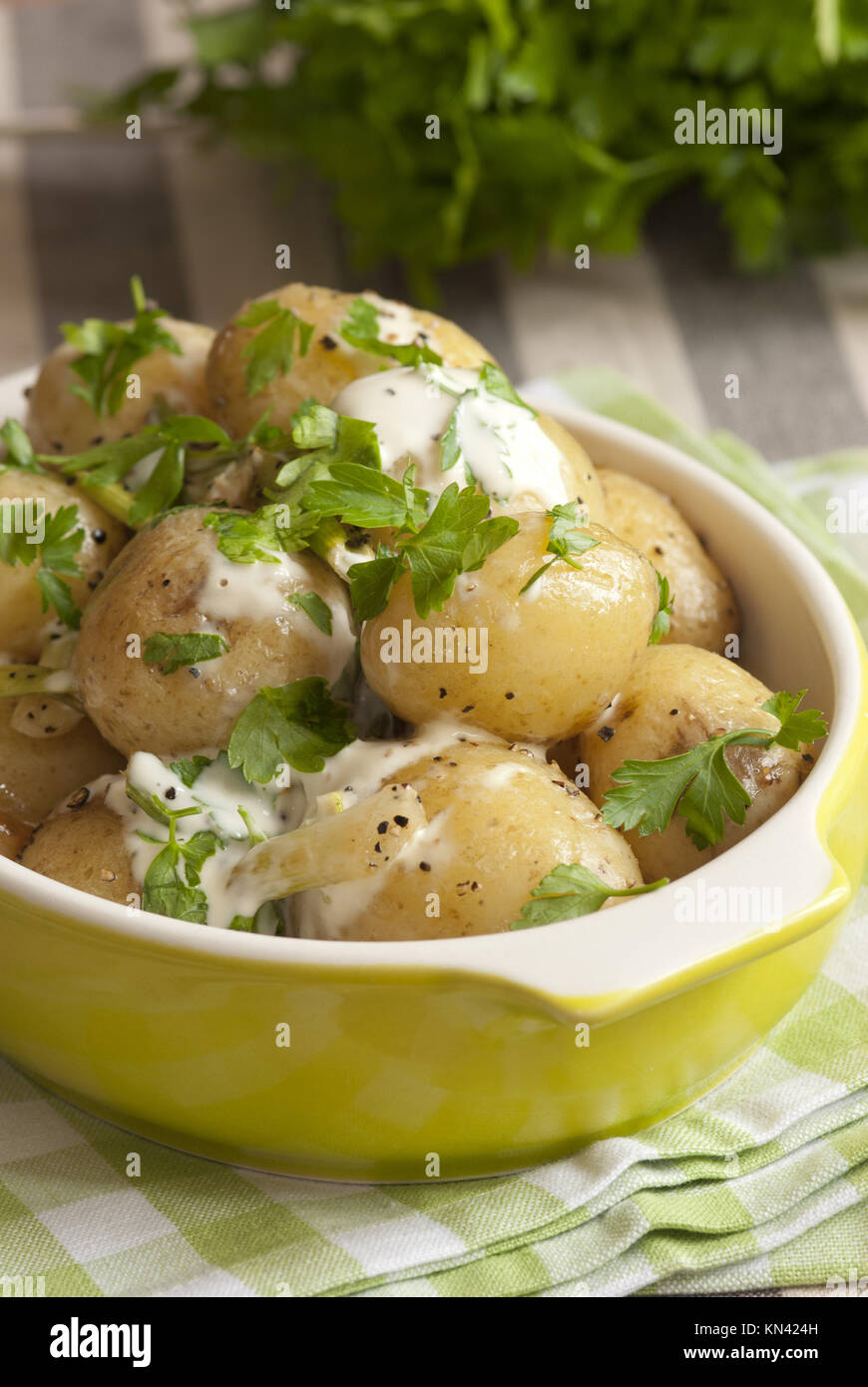 Freshly baked new potatoes with creme fraiche and parsley. Stock Photo