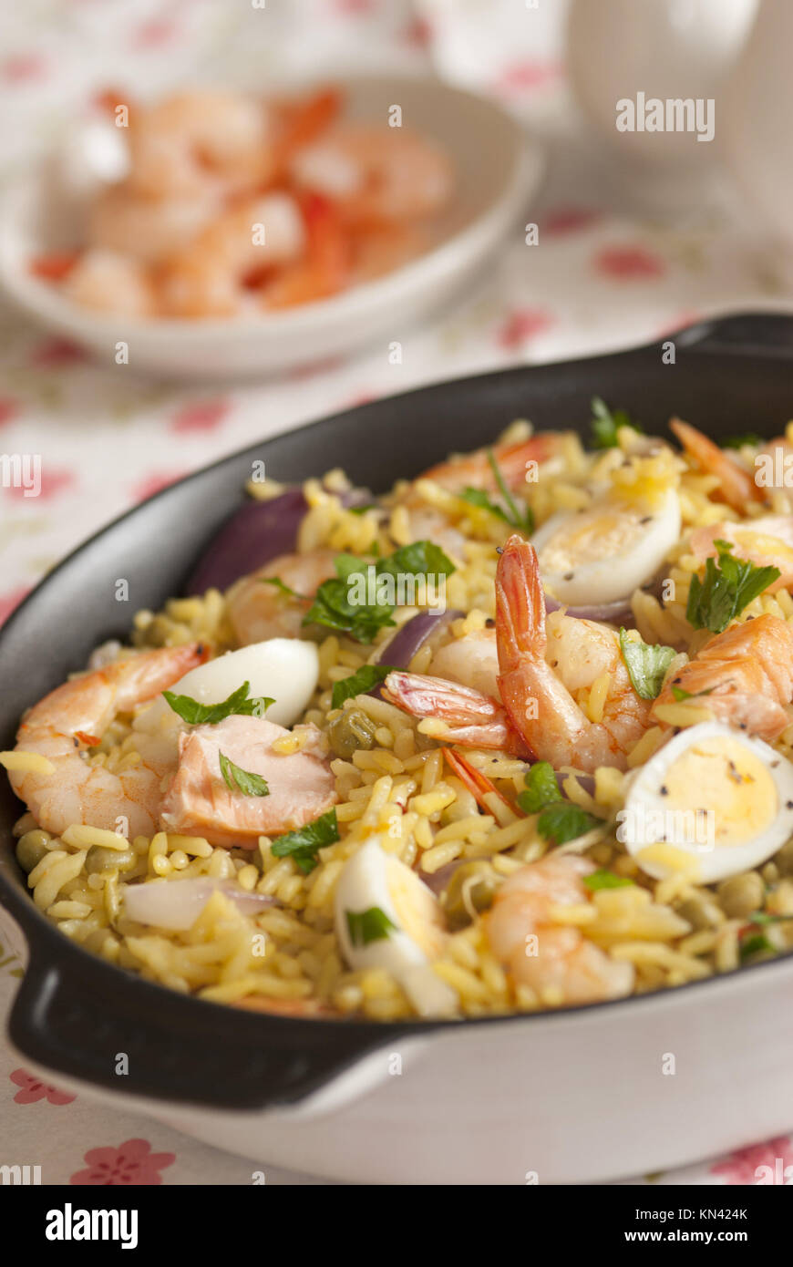 Kedgeree with salmon, seafood and quails eggs. Stock Photo