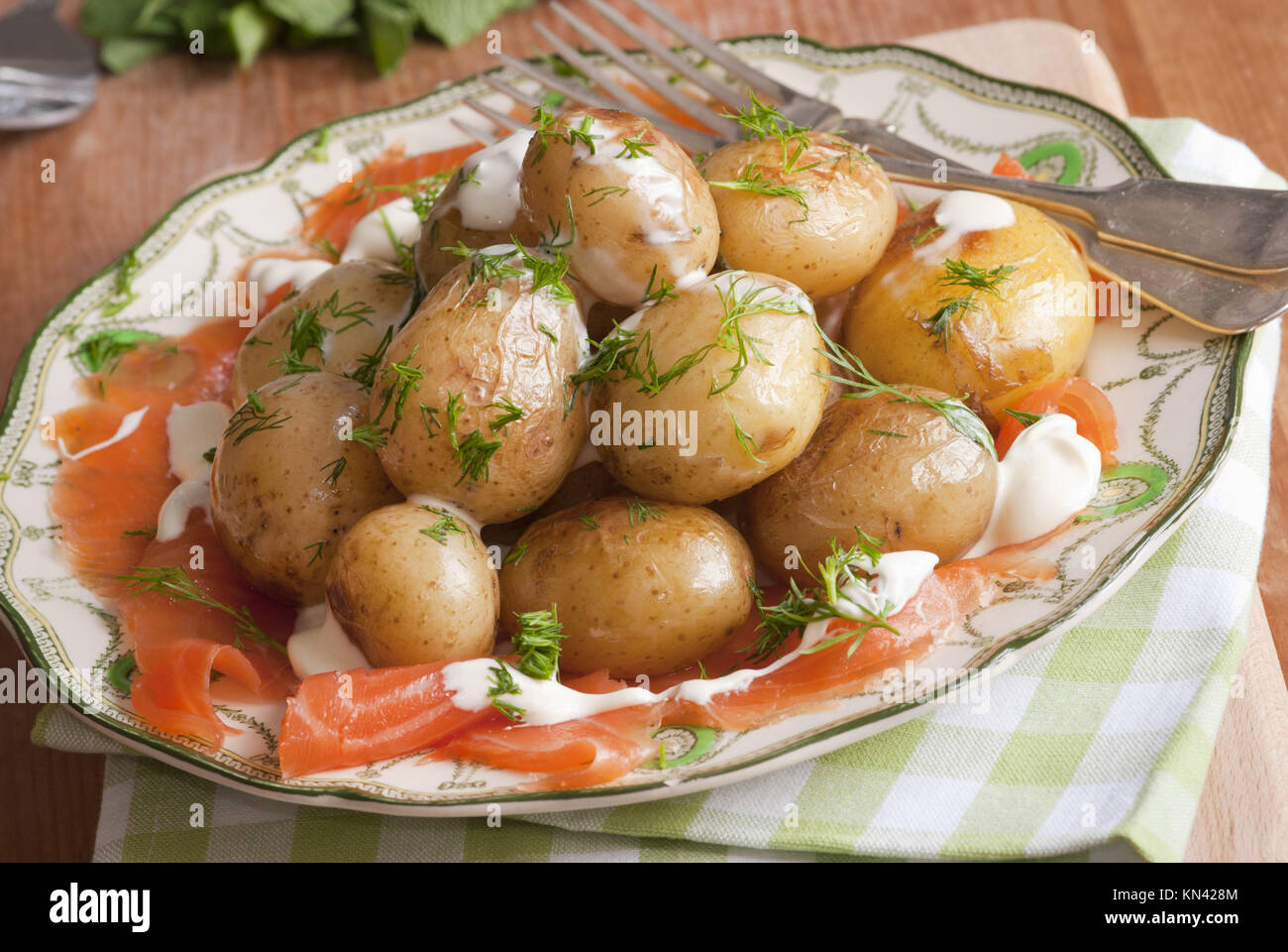 New potatoes with smoked salmon and creme fraiche on a plate. Stock Photo
