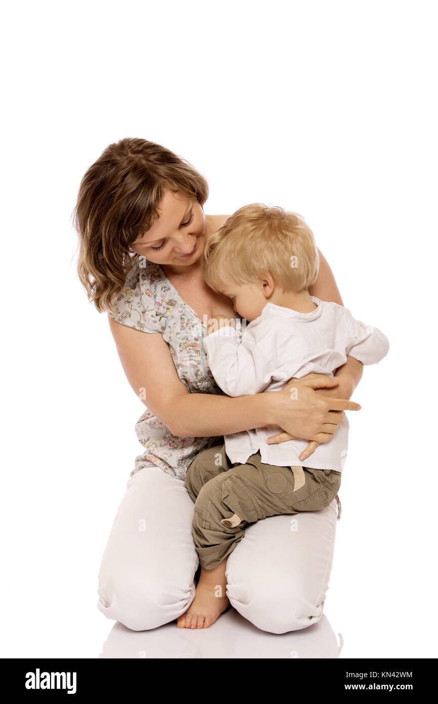 Young boy sitting on mother lap. Isolated on white background Stock