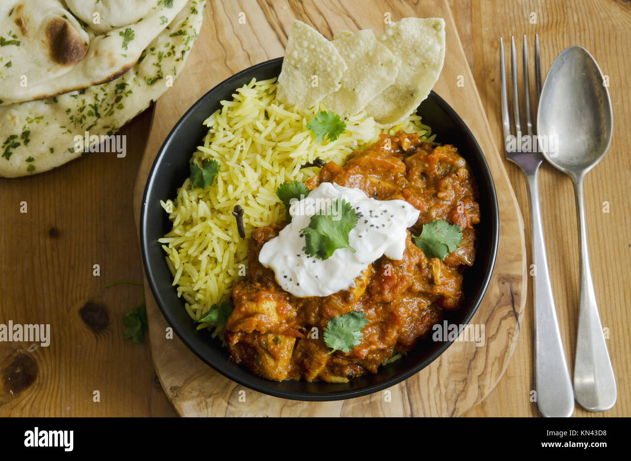 Jalfrezi Indian chicken curry with pilau rice and pappadoms. Stock Photo