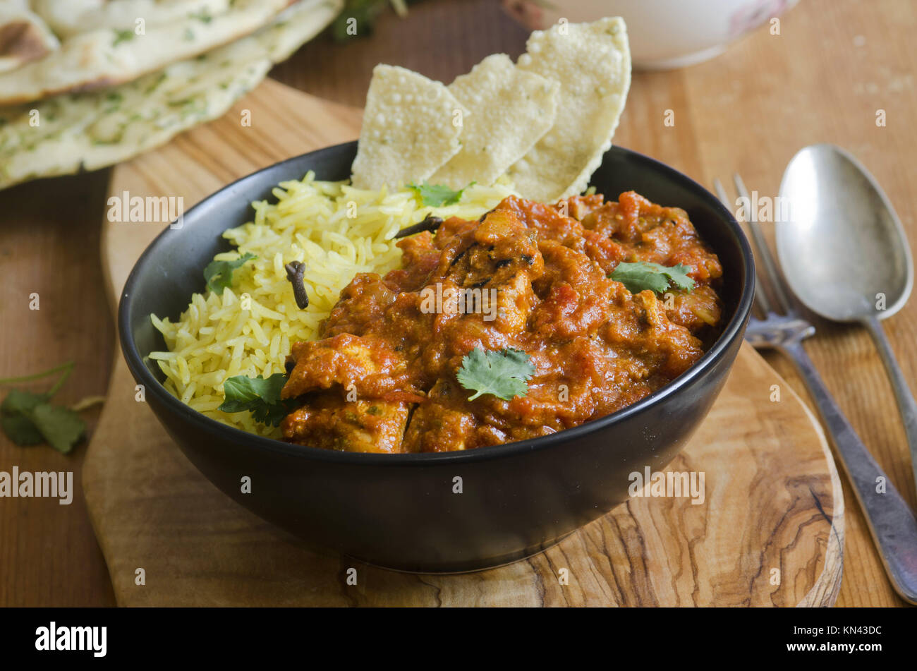 Jalfrezi Indian chicken curry with pilau rice and pappadoms. Stock Photo