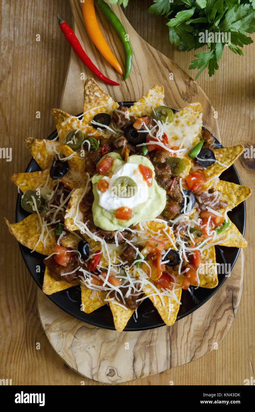 Spicy Nachos with beef, chilli peppers, sour cream and guacamole Stock