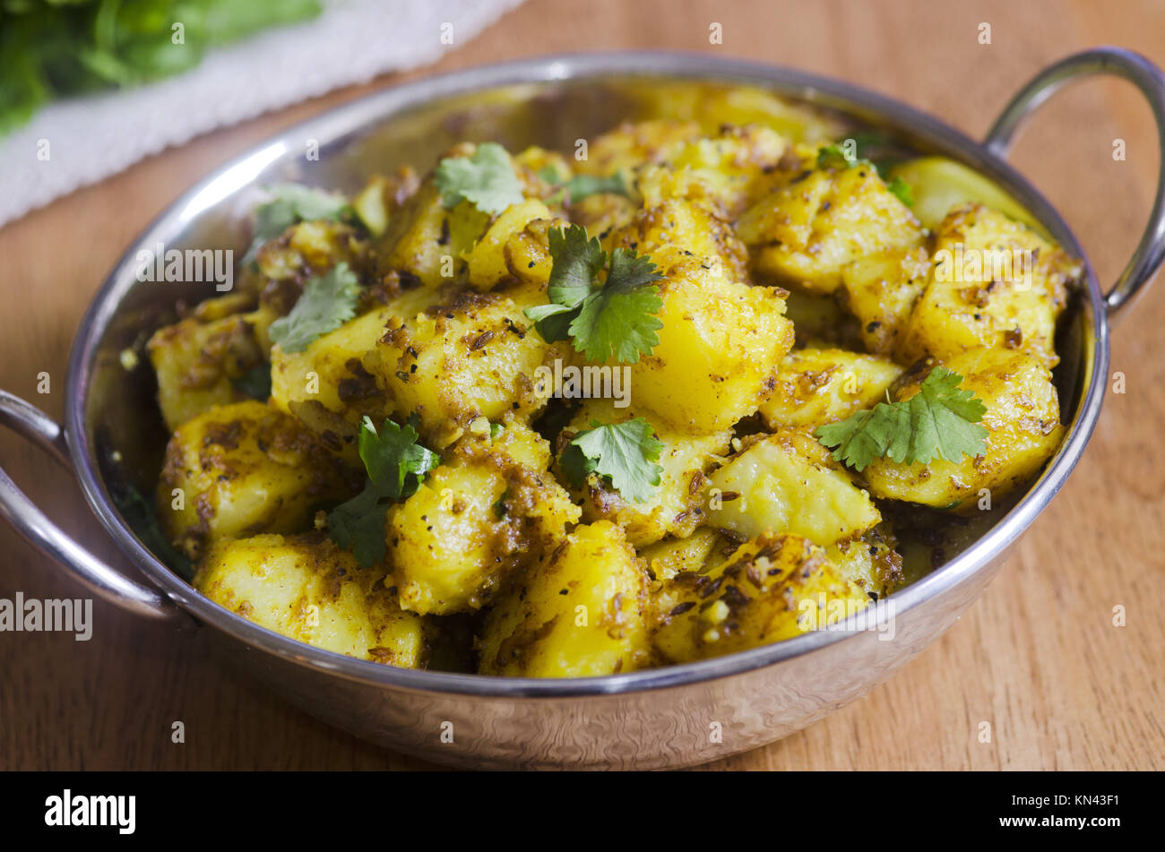 Indian spiced potato curry topped with coriander Stock Photo Alamy