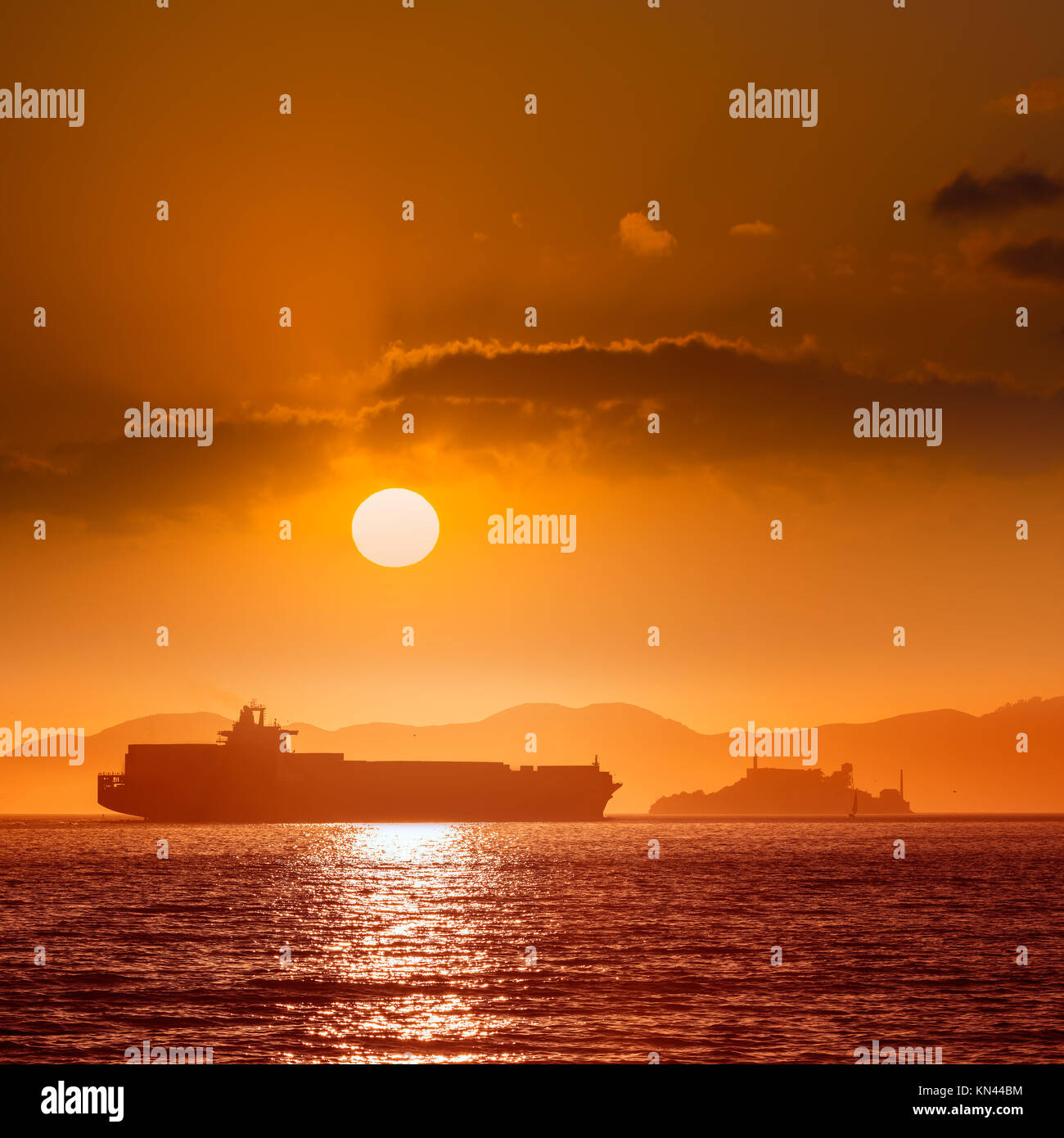 Alcatraz island penitentiary at sunset and merchant ship in san Francisco California USA. Stock Photo