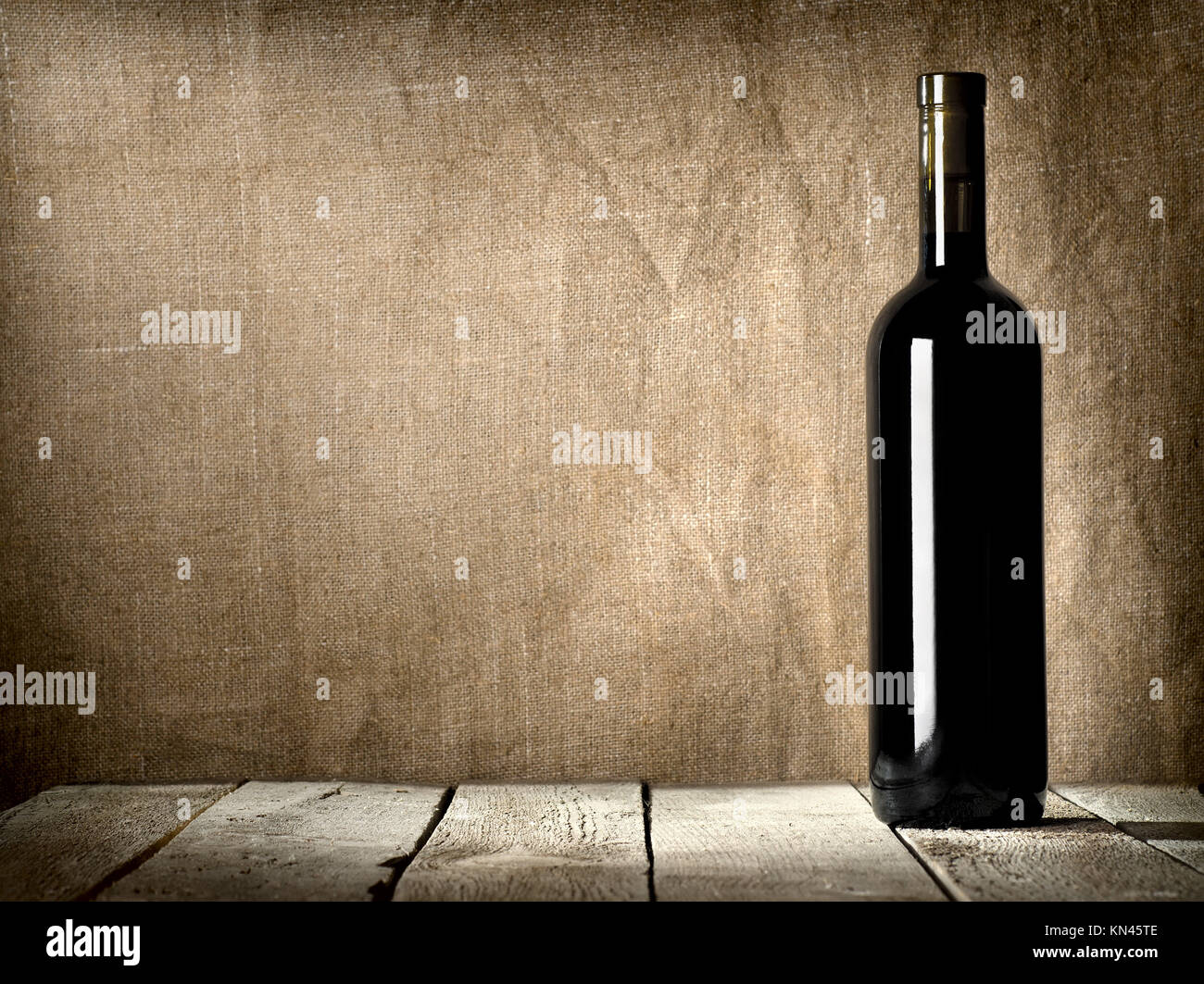 Black bottle of wine on the background of the canvas. Stock Photo