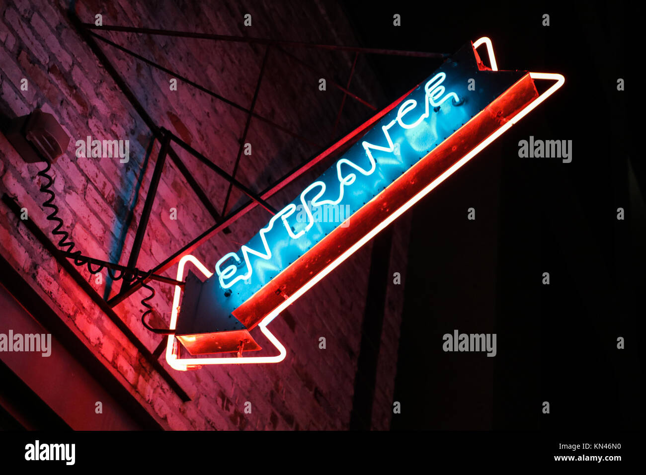 Neon Entrance Sign on Building at Night Stock Photo