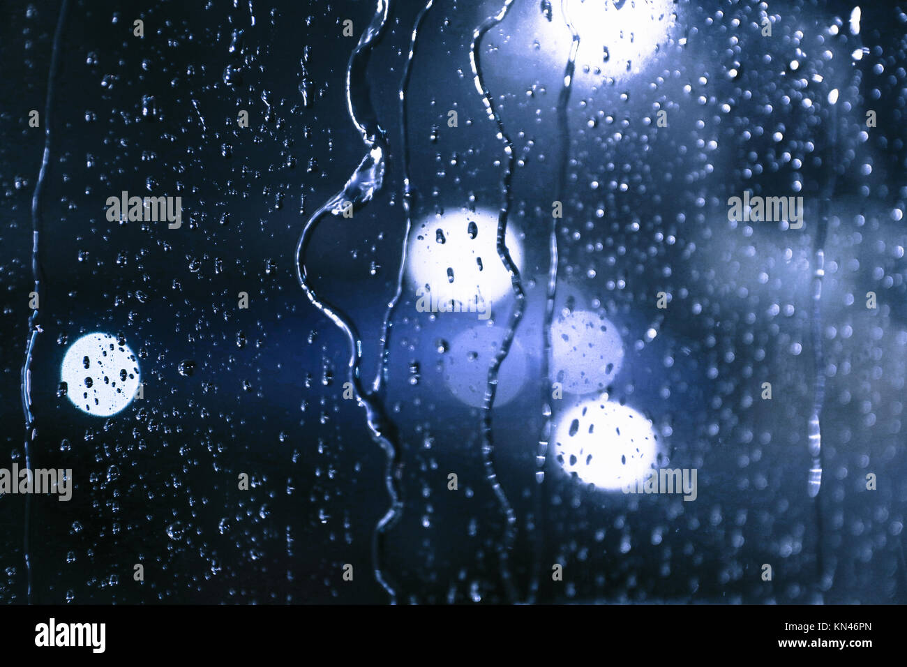 Rain on Airplane Window at Night with Bokeh Stock Photo