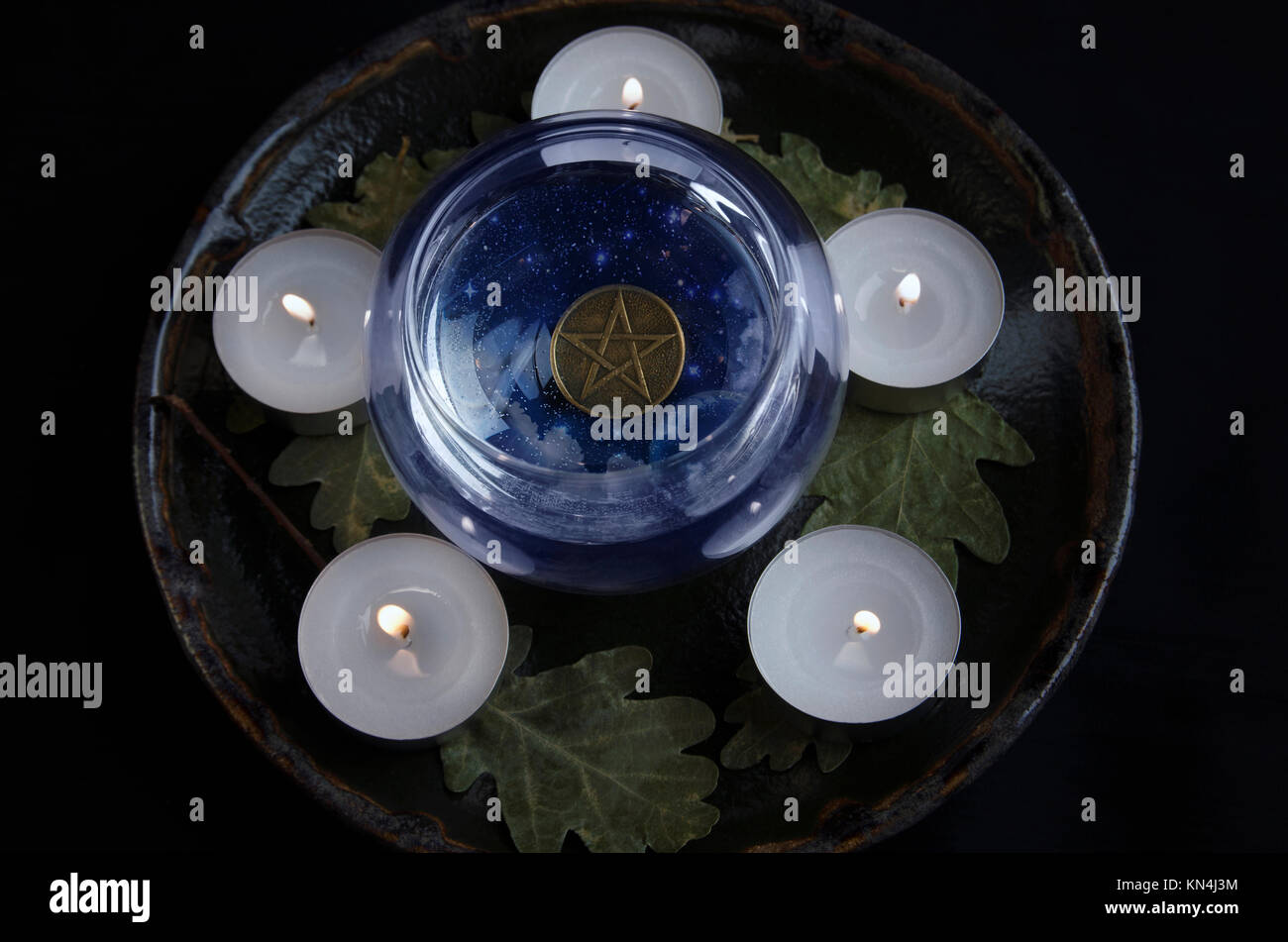 Circle of candles with pentagram in crystal ball Stock Photo