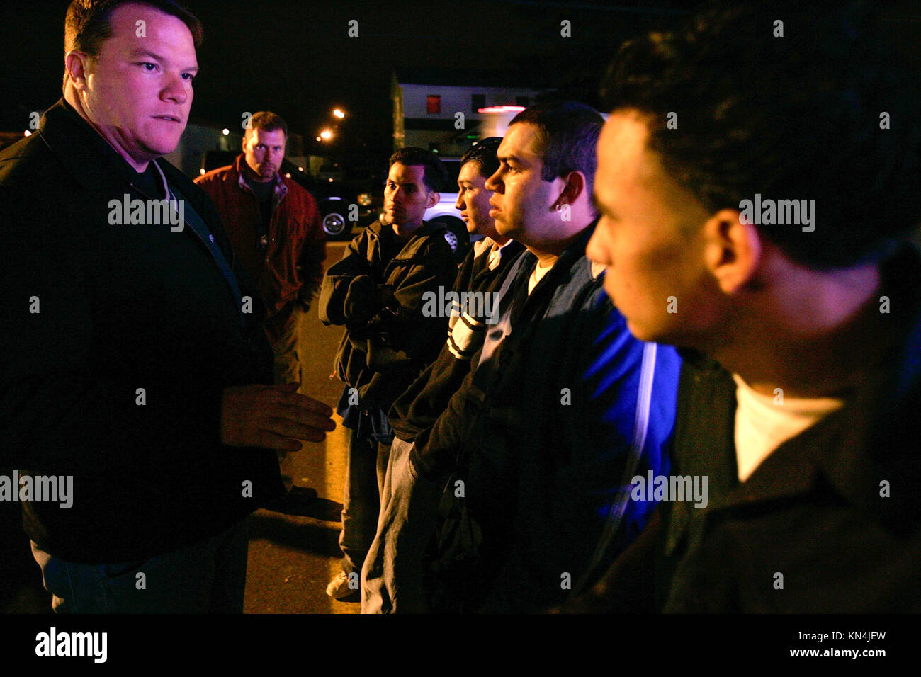 Suffolk County Police officers from the anti-gang unit check identity papers of possible gang members of Mara Salvatrucha 13 or MS-13, in Brentwood, New York. Many of the MS-13 members are in the U.S. illegally with false documents. Two of the four youths are  MS-13 members, first and second right.  Mara Salvatrucha 13 started in the 1980's in Los Angeles, California during the 12-year civil war in El Salvador when refugees fled north for safety and employment. Stock Photo