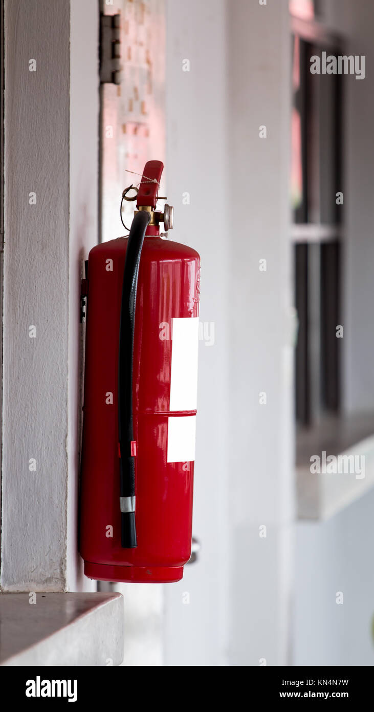 Fire extinguisher on wall background Stock Photo - Alamy