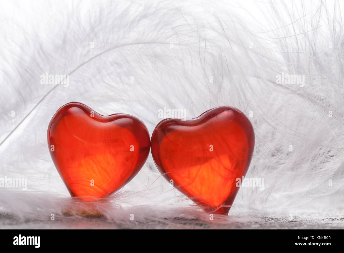 Red heart on a white feathers Stock Photo